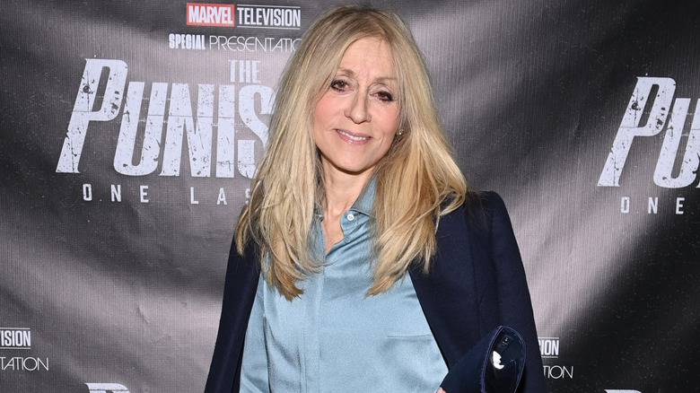 Judith Light smiling in a light blue shirt and dark blue jacket.