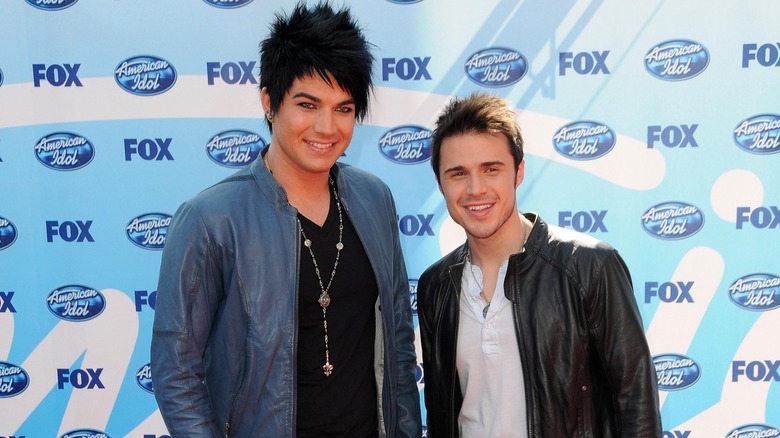 Adam Lambert smiles alongside Kris Allen on the red carpet
