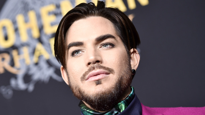 A bearded Adam Lambert looking stoic