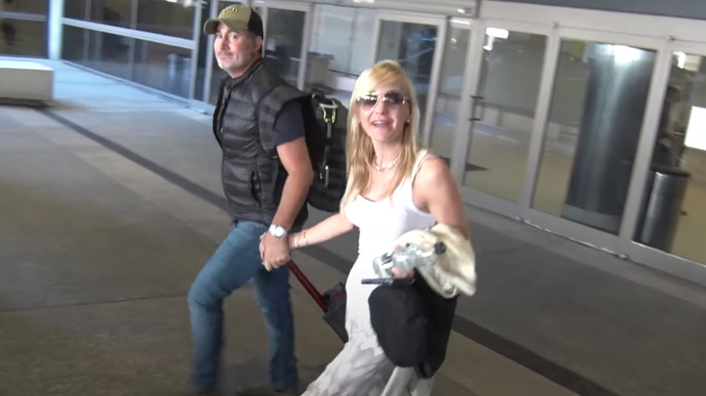 Michael Barrett and Anna Faris holding hands at the airport