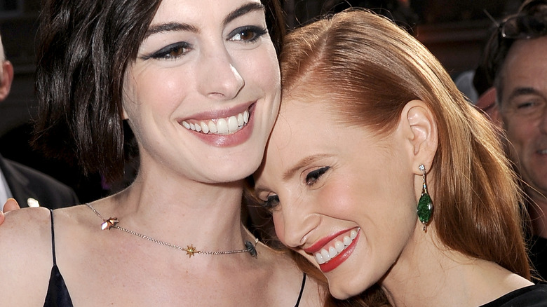 Anne Hathaway and Jessica Chastain laugh at an event