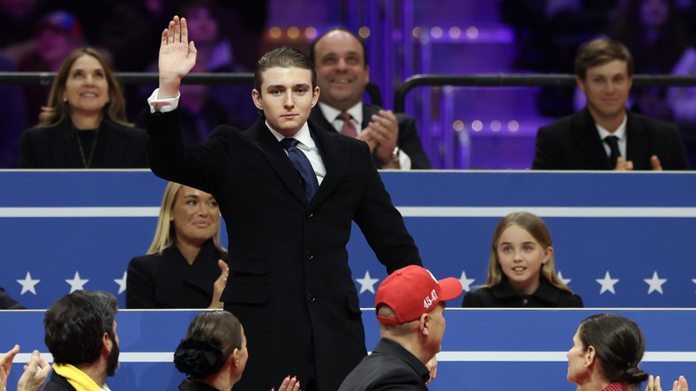 Barron Trump waving to the crowd during an indoor inauguration parade at Capital One Arena