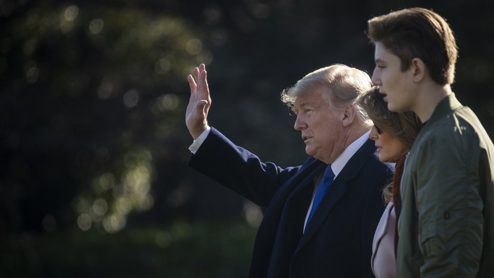 Profile of Barron Trump walking outside with Melania and Donald Trump