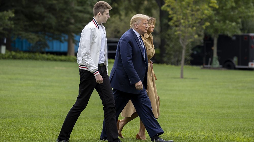 A taller Barron Trump walking alongside Donald and Melania Trump