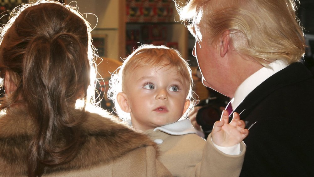Melania Trump holding baby Barron Trump next to Donald Trump
