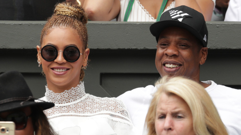 Beyoncé and Jay Z smiling, watching tennis game