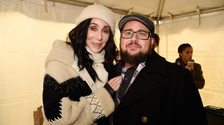 Cher posing with Chaz Bono, with both wearing winter garb