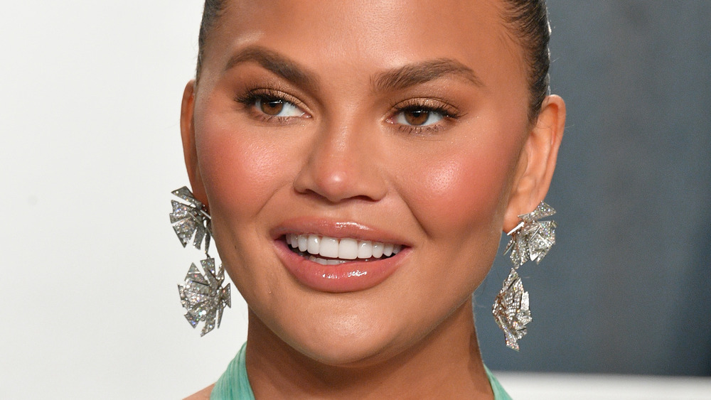 Chrissy Teigen poses and smiles