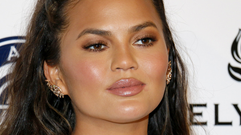 Chrissy Teigen with earclaws looking to the side