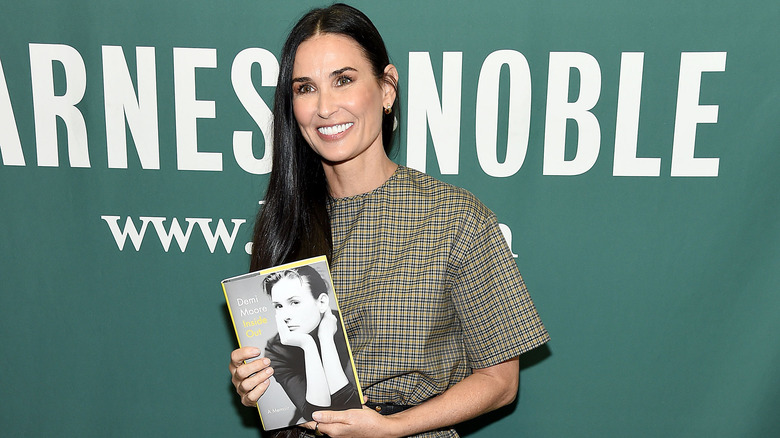 Demi Moore holding her book