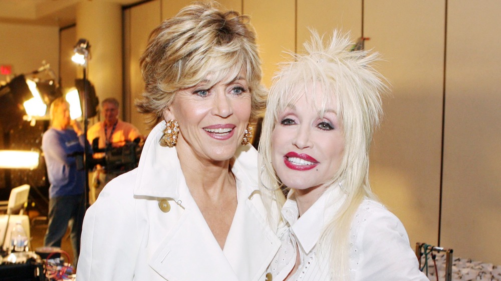 Dolly Parton and Jane Fonda smiling while wearing white