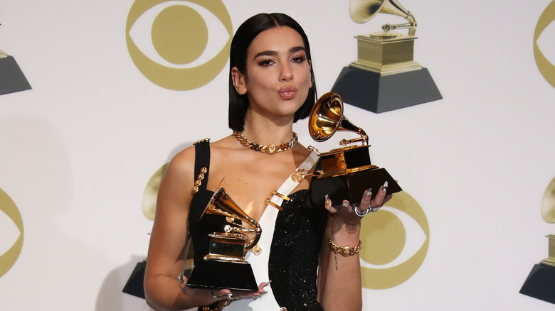 Dua Lipa posing with her Grammy Awards