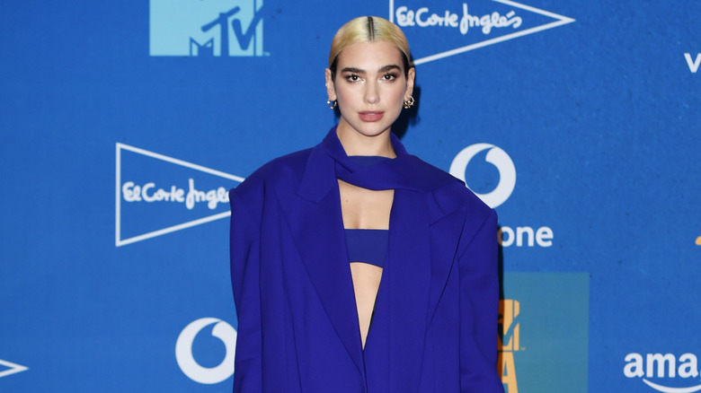 Dua Lipa on the red carpet, posing all in blue