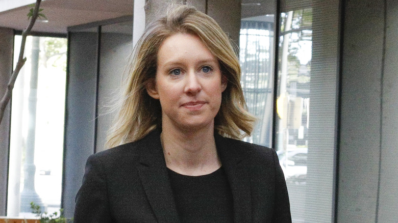 Elizabeth Holmes walking outside in black blazer