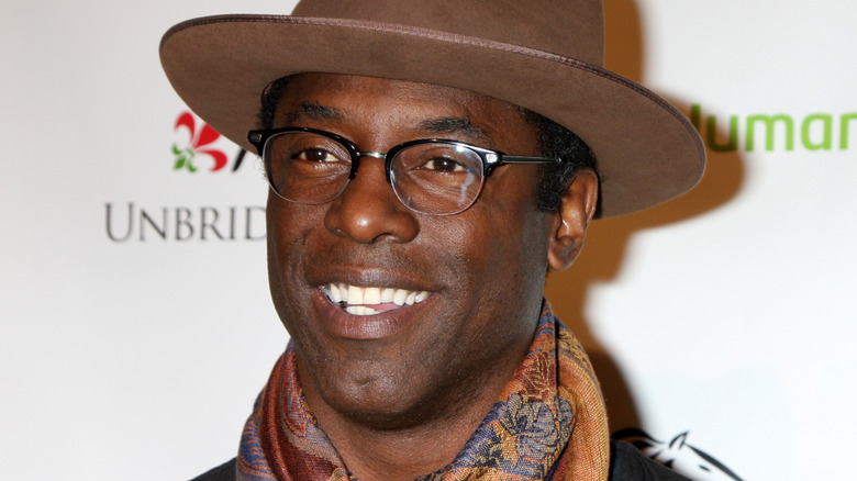 Isaiah Washington smiles in a brown hat
