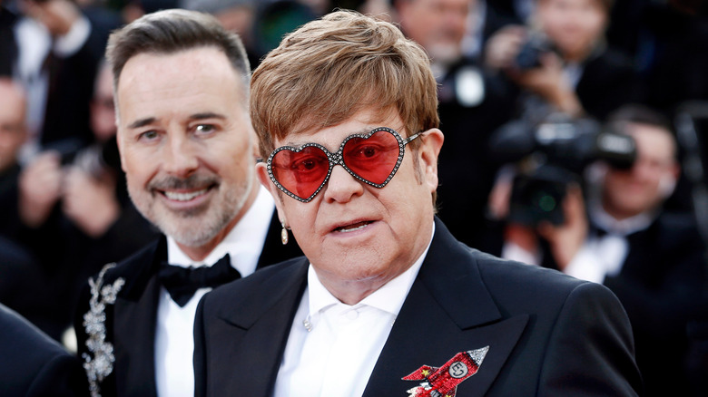 David Furnish smiling over Elton John's shoulder
