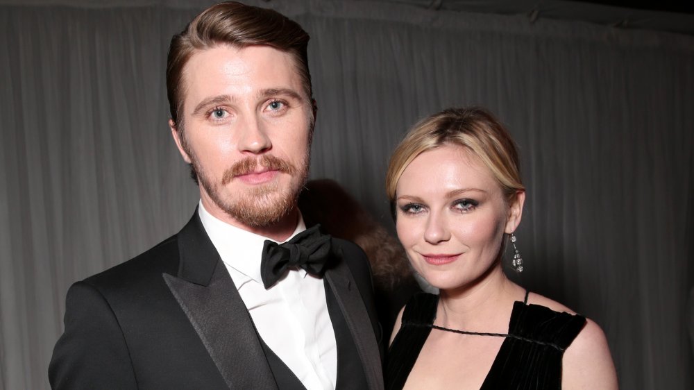 Garrett Hedlund and Kirsten Dunst, posing together, both in black