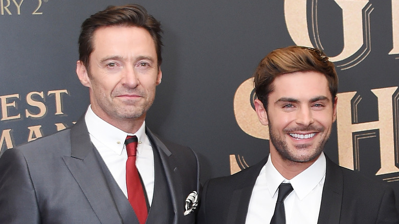 Hugh Jackman and Zac Efron posing