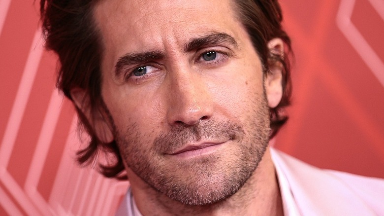 Jake Gyllenhaal in front of a red background