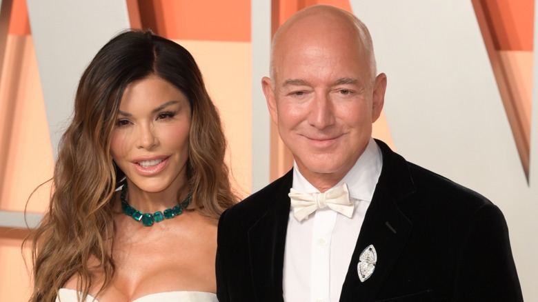 Jeff Bezos and Lauren Sanchez look down while smiling.