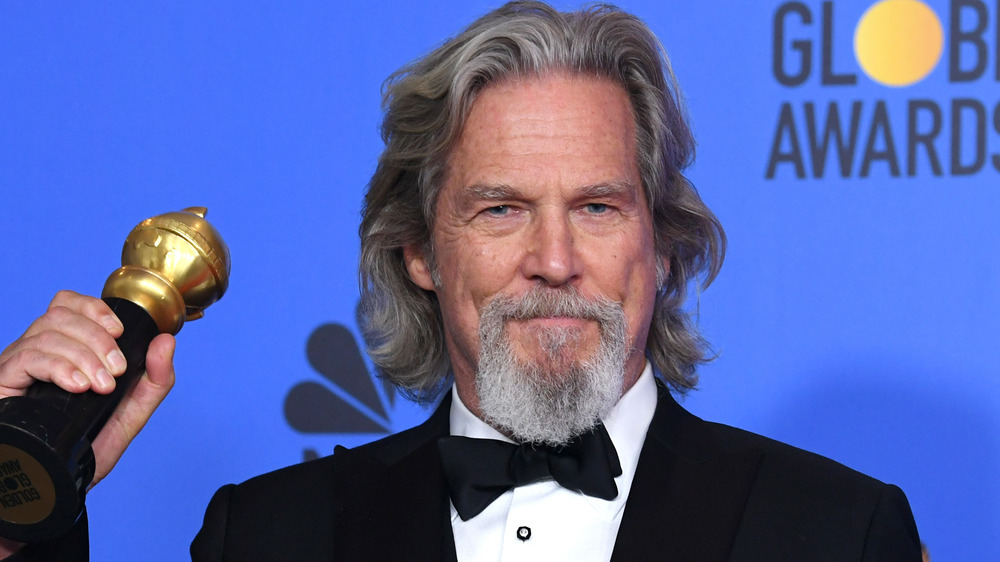 Jeff Bridges posing with an award