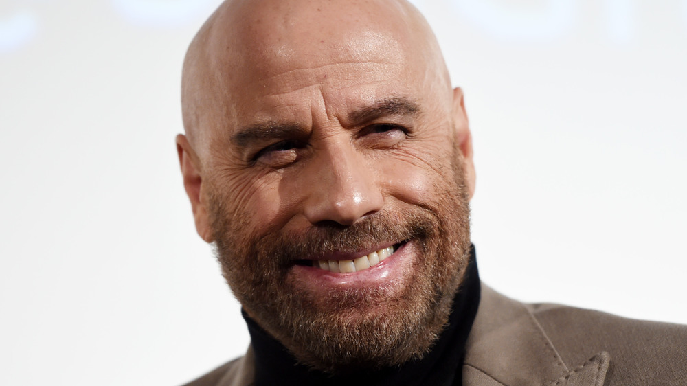 John Travolta smiles at a red carpet event