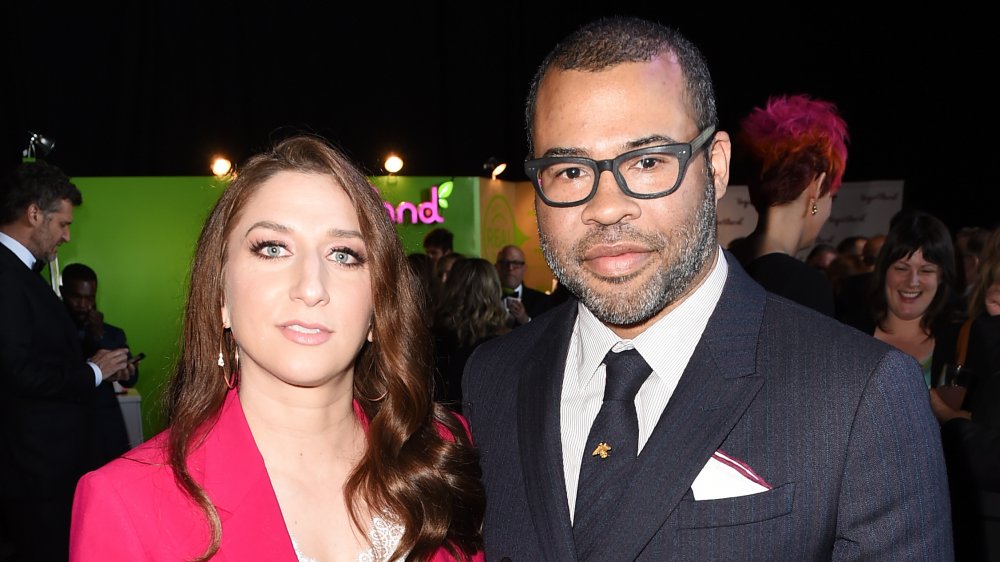 Chelsea Peretti in a pink blazer, Jordan Peele in a black-and-blue pin-striped suit and glasses