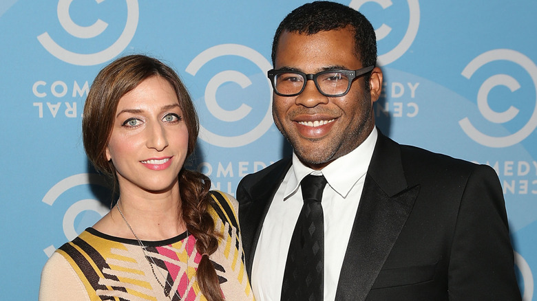 Chelsea Peretti in a yellow-and-black dress, Jordan Peele in a black suit and glasses