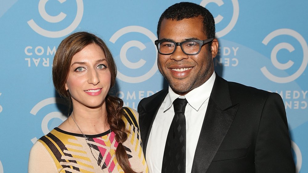 Chelsea Peretti in a yellow-and-black dress, Jordan Peele in a black suit and glasses