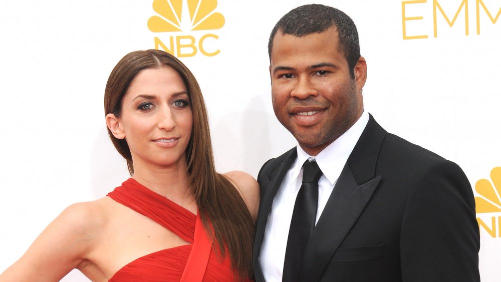 Chelsea Peretti in a red dress, Jordan Peele in a black suit, both smiling at the Emmys