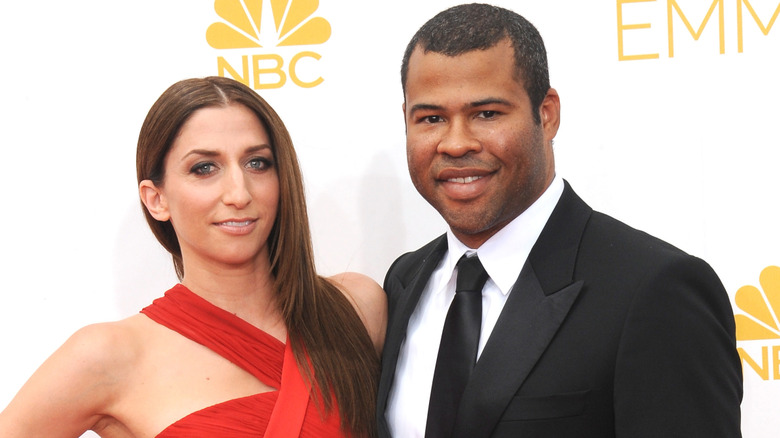 Chelsea Peretti in a red dress, Jordan Peele in a black suit, both smiling at the Emmys
