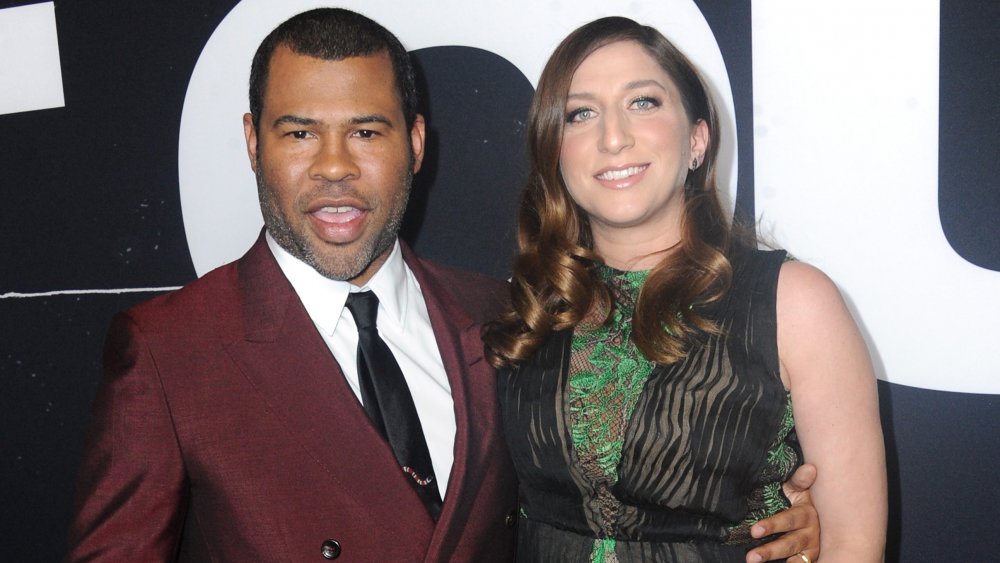 Jordan Peele in a maroon suit, Chelsea Peretti in a green-and-black dress