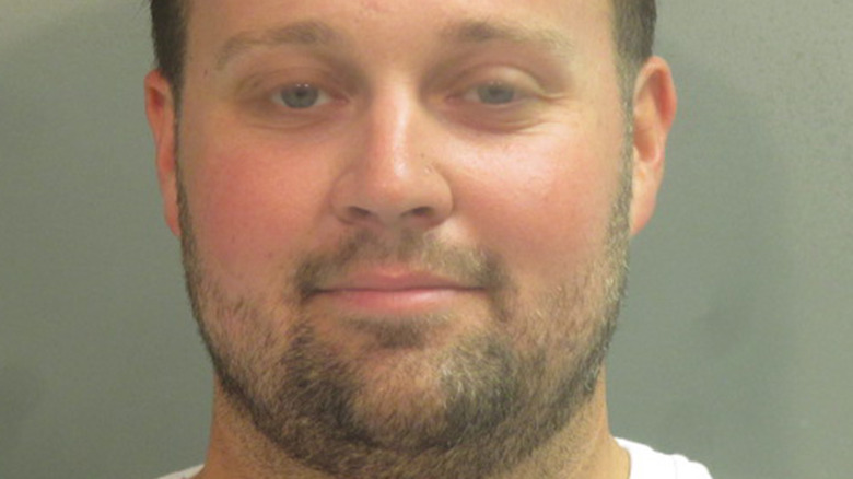 Josh Duggar smiles in a mugshot