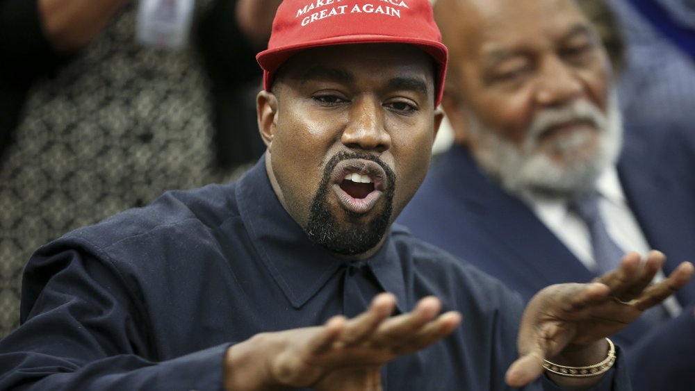 Kanye West wearing a MAGA hat, speaking