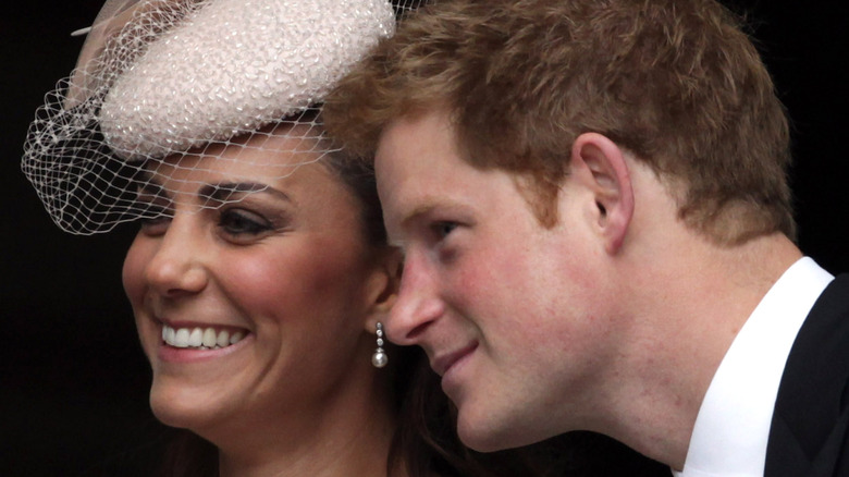 Kate Middleton laughs as Harry whispers