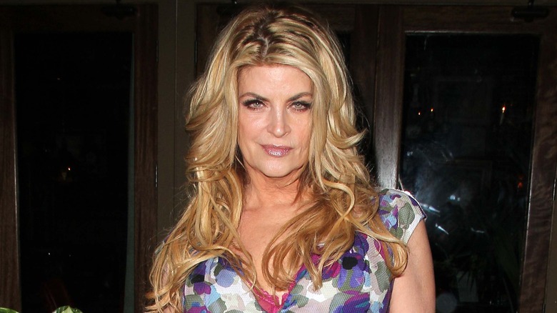 Kirstie Alley in front of plants