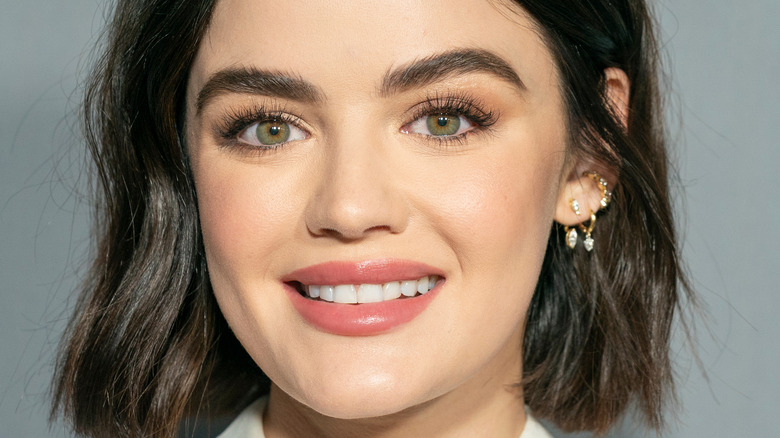 Lucy Hale smiles in a white collared top