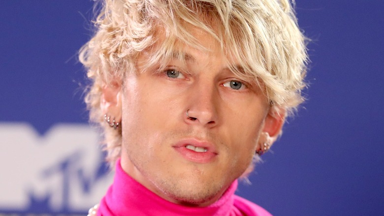 Machine Gun Kelly wearing a pink turtle neck