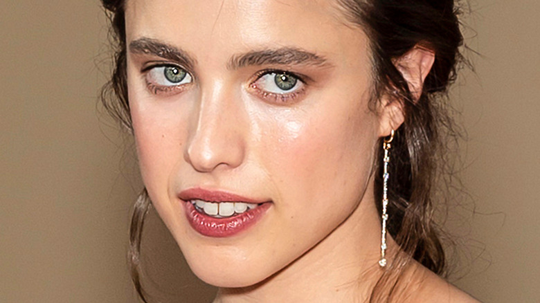 Margaret Qualley poses in a sparkly top.