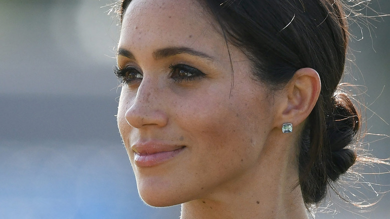 Meghan Markle smiling with messy bun