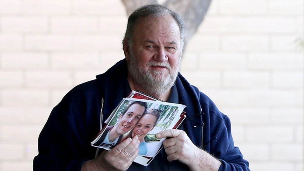 Thomas Markle holding photoraphs