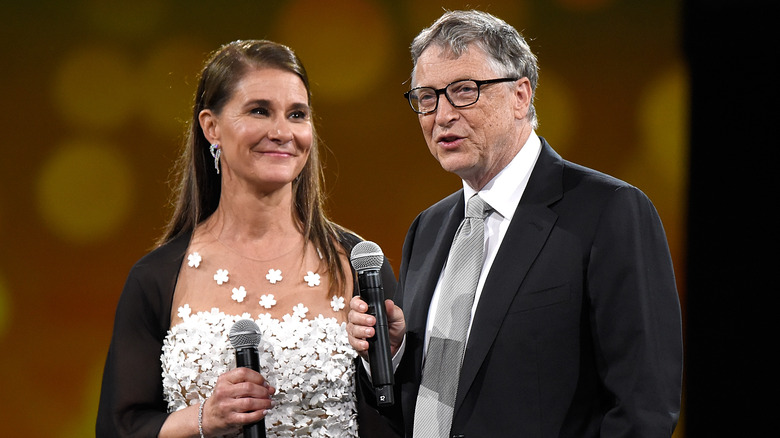 Melinda and Bill Gates holding microphones. 