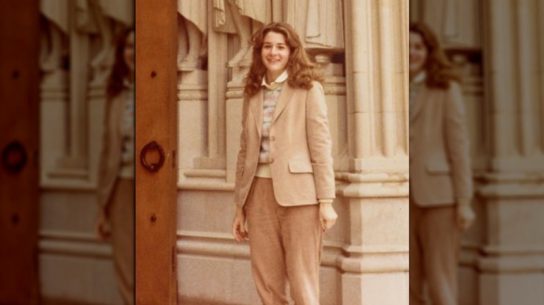 A young Melinda Gates in front of pillars and statues 