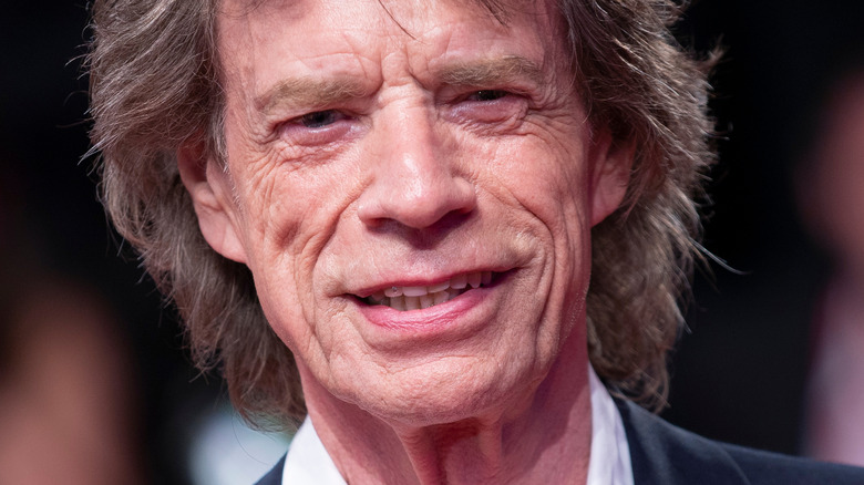 Mick Jagger smiling and wearing suit