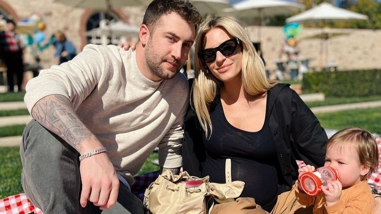 Jordan McGraw, Morgan Stewart, and daughter Row on a picnic blanket