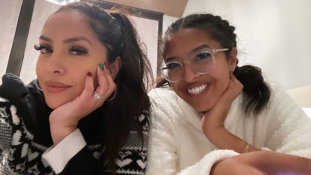 Vanessa Bryant in a pony tail and sweater taking a selfie, Natalia Bryant, smiling, in braids, in glasses