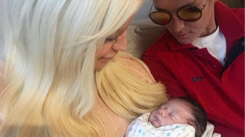 Gigi Gorgeous and Nats Getty holding a newborn