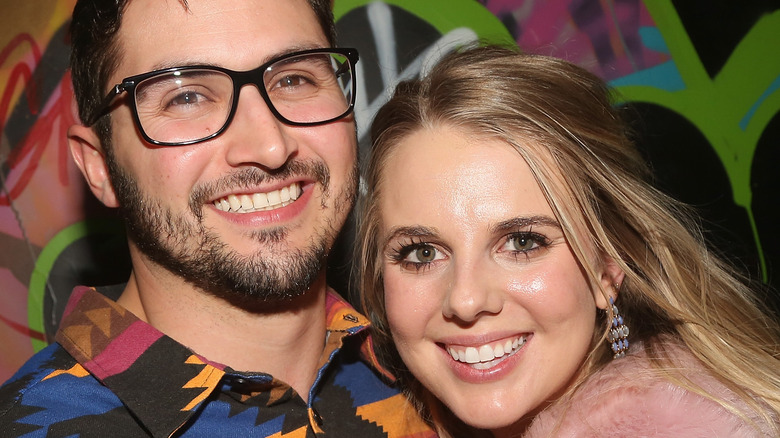 Victor Arroyo and Nicole Franzel smile and snuggle