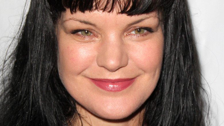 Pauley Perrette smiles with bangs and hair down