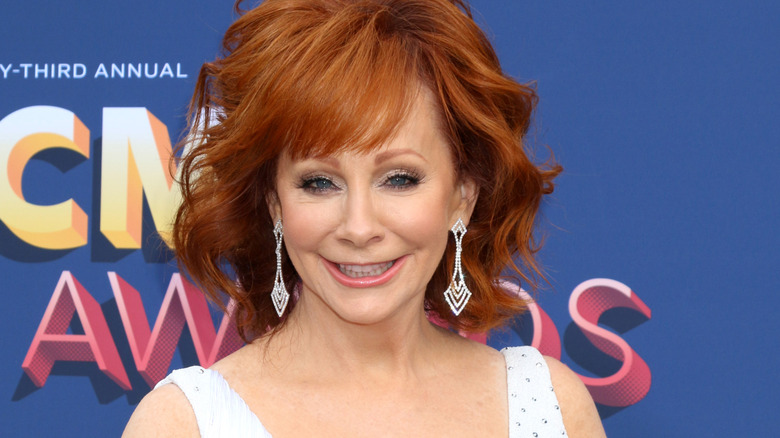 Reba McEntire dangly earrings white dress